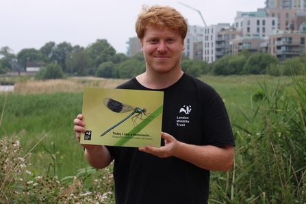 London Wildlife Trust staff member holds a copy of the guide book