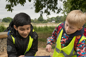 Two boys from Jubilee Primary School pond dipping at woodberry wetlands