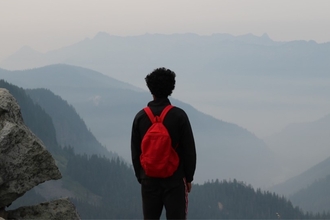 A young man looking over a mountain few.