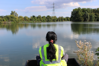 Keeping It Wild Trainee Naomi sat in front of the water at Walthamstow wetlands.