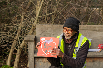 A person holding a red square book that reads A Slug in Love