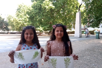 Two young girls hold up their hapa zome art work