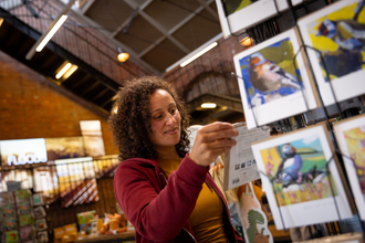 Woman browsing the greetings cards, shopping at Walthamstow Wetlands