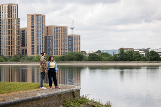 Two people stood on a concrete ledge overlooking water