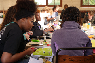 A group of young people around a table taking part in a workshop