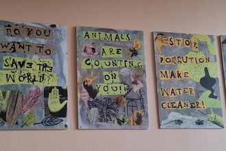 Five hand made zines with pro-nature messages are laid out on a desk