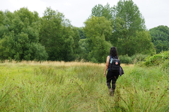 Woman walking through Fray's Farm Meadows