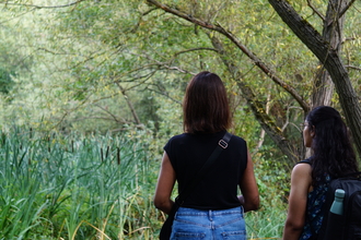 Two women looking out at greenery at Park Road Pond