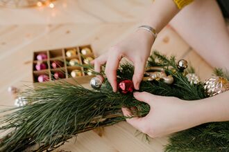 Close-up shot of a person holding a festive wreath