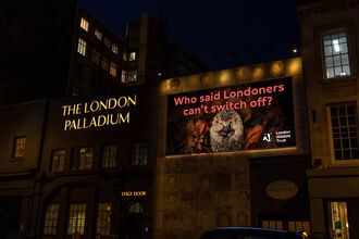 People walk past The London Palladium beneath a large London Wildlife Trust billboard showing a hedgehog with the message, “Who said Londoners can’t switch off?”
