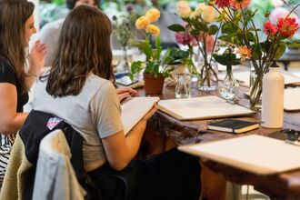 Image of a woman drawing some flowers in a classroom