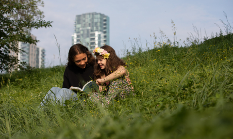 Adult reading child a story at Woodberry Wetlands