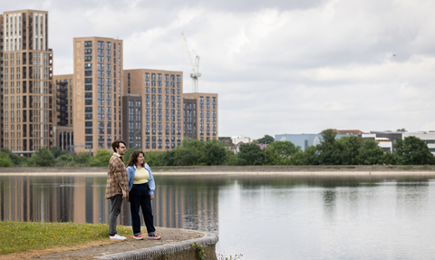 Two people stood on a concrete ledge overlooking water