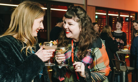 Two people smiling at each other at a christmas party
