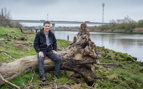 Jeremy sat on a log next to a river