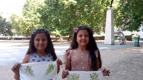 Two young girls hold up their hapa zome art work