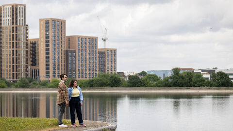 Two people stood on a concrete ledge overlooking water