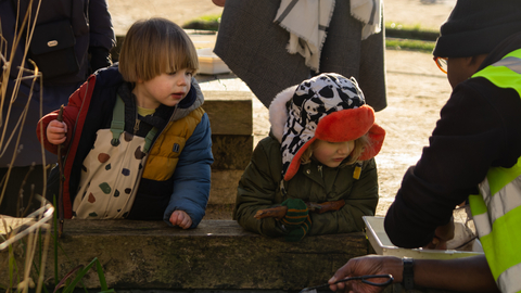Two children looking into a pond tray