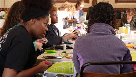 A group of young people around a table taking part in a workshop