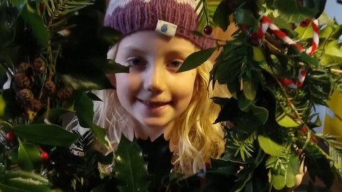 girl holding a wreath