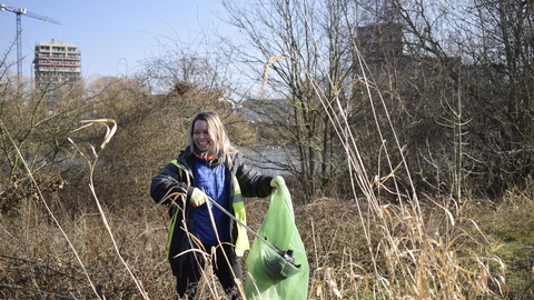 A woman litter picking in an urban nature reserve 