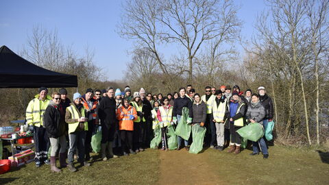A group of people holding equipment after a litter pick 