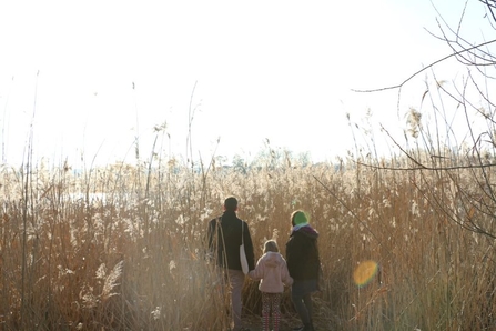 A family of three standing in the reeds