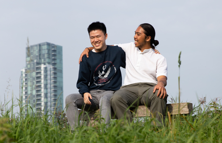 Two young people sitting on bench at Woodberry Wetlands 