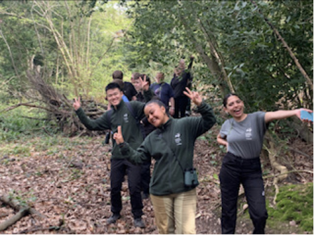 Young people in woodland waving 