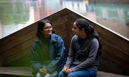 Two young people sat by the water at Camley Street Reserve 