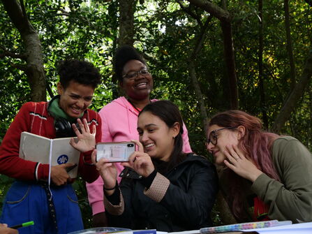 young people laughing at image on a phone