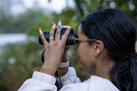 A person using binoculars to birdwatch