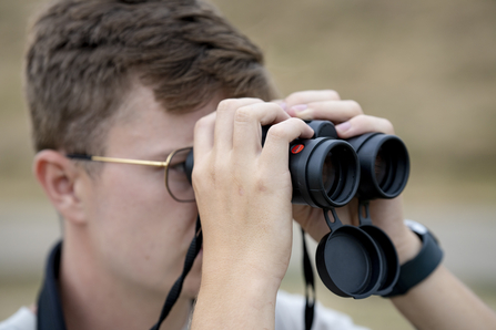 A person using binoculars to birdwatch
