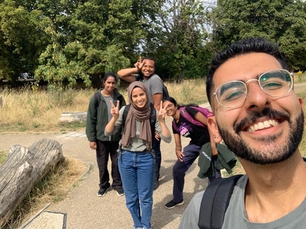 5 keeping it wild trainees (young adults) smiling and posing for a selfie.