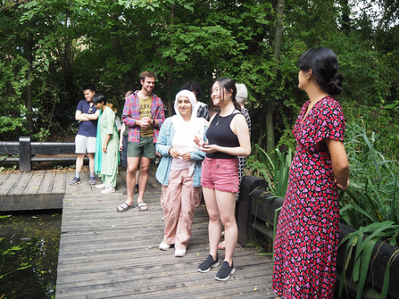 Young people standing around pond at Camley Street Natural Park 