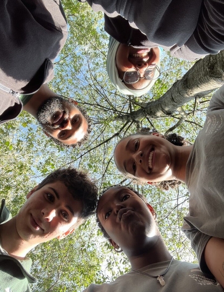 2023 trainees smiling together with a tree canopy above them