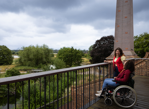 Two people laughing on the terrace at Walthamstow Wetlands