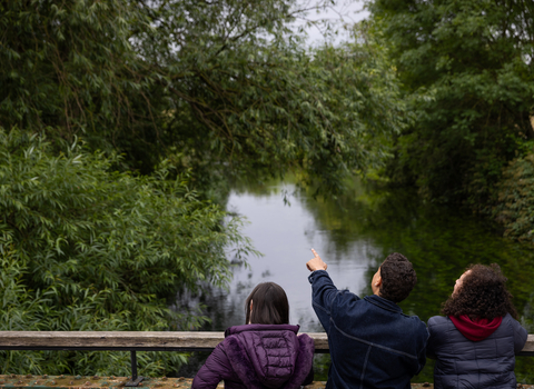 Three people looking over bridge at Walthamstow Wetlands