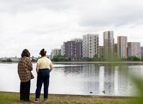 Two people looking over the water at Walthamstow Wetlands