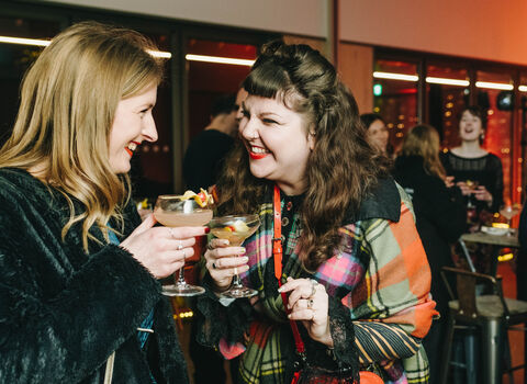 Two people smiling at each other at a christmas party